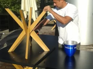 Angelo, titolare della Mya Traslochi che assembla la base in legno di un tavolo all'Expo 2015 Milano