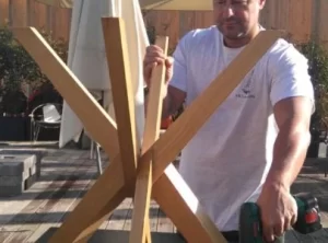 Angelo, titolare della Mya Traslochi, regge le gambe in legno di un tavolo durante lo smontaggio, Expo 2015 Milano