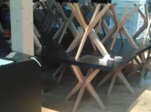 Tavoli con base in legno e piano nero impilati su una terrazza, Expo 2015 Milano